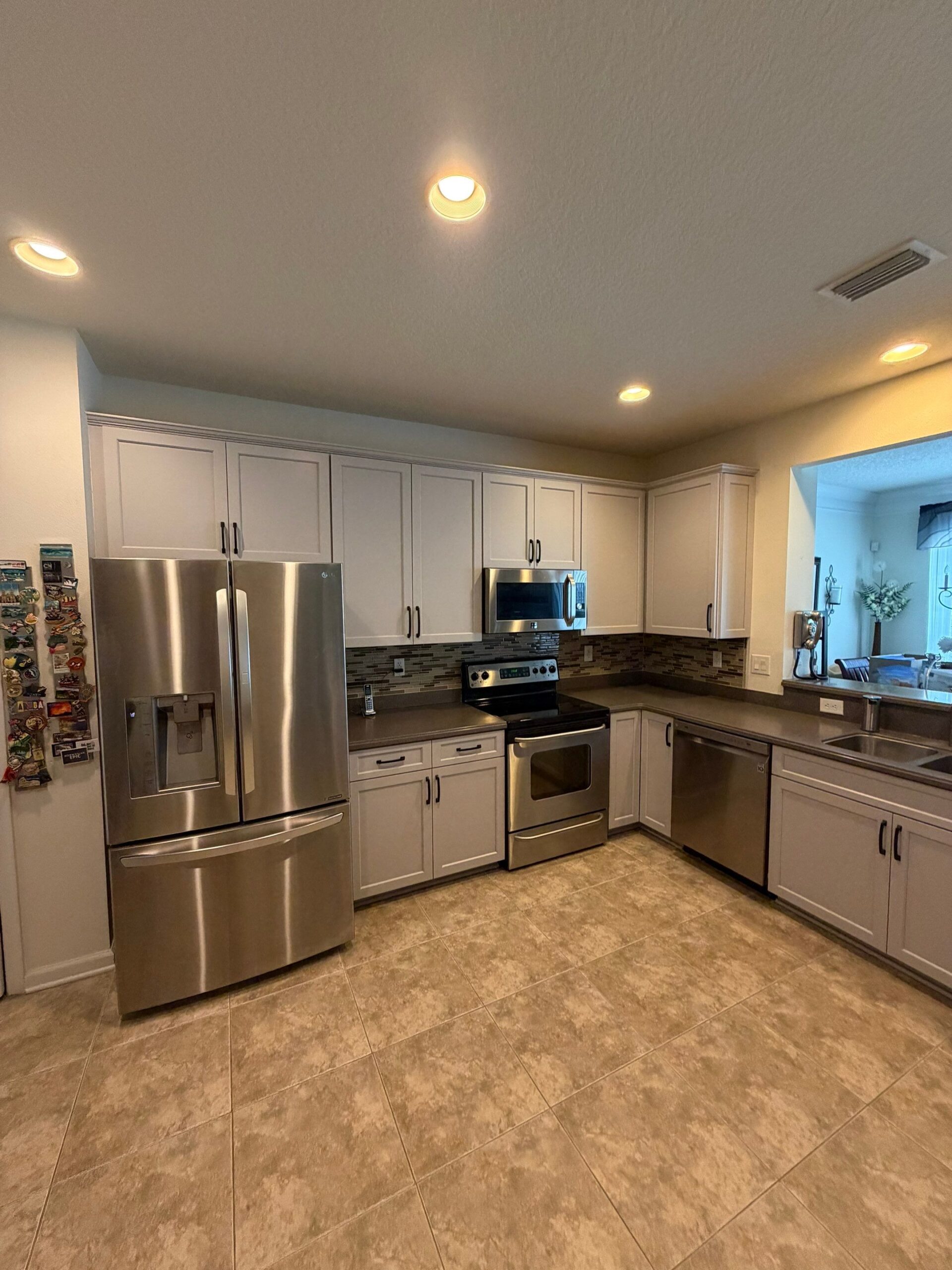 Custom kitchen cabinetry with white shaker cabinets, stainless appliances, and island, custom cabinets Jacksonville