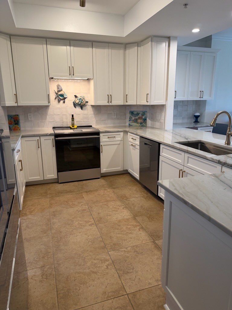 cabinet refacing Jacksonville kitchen with white shaker cabinets, stainless appliances, and gray tile backsplash