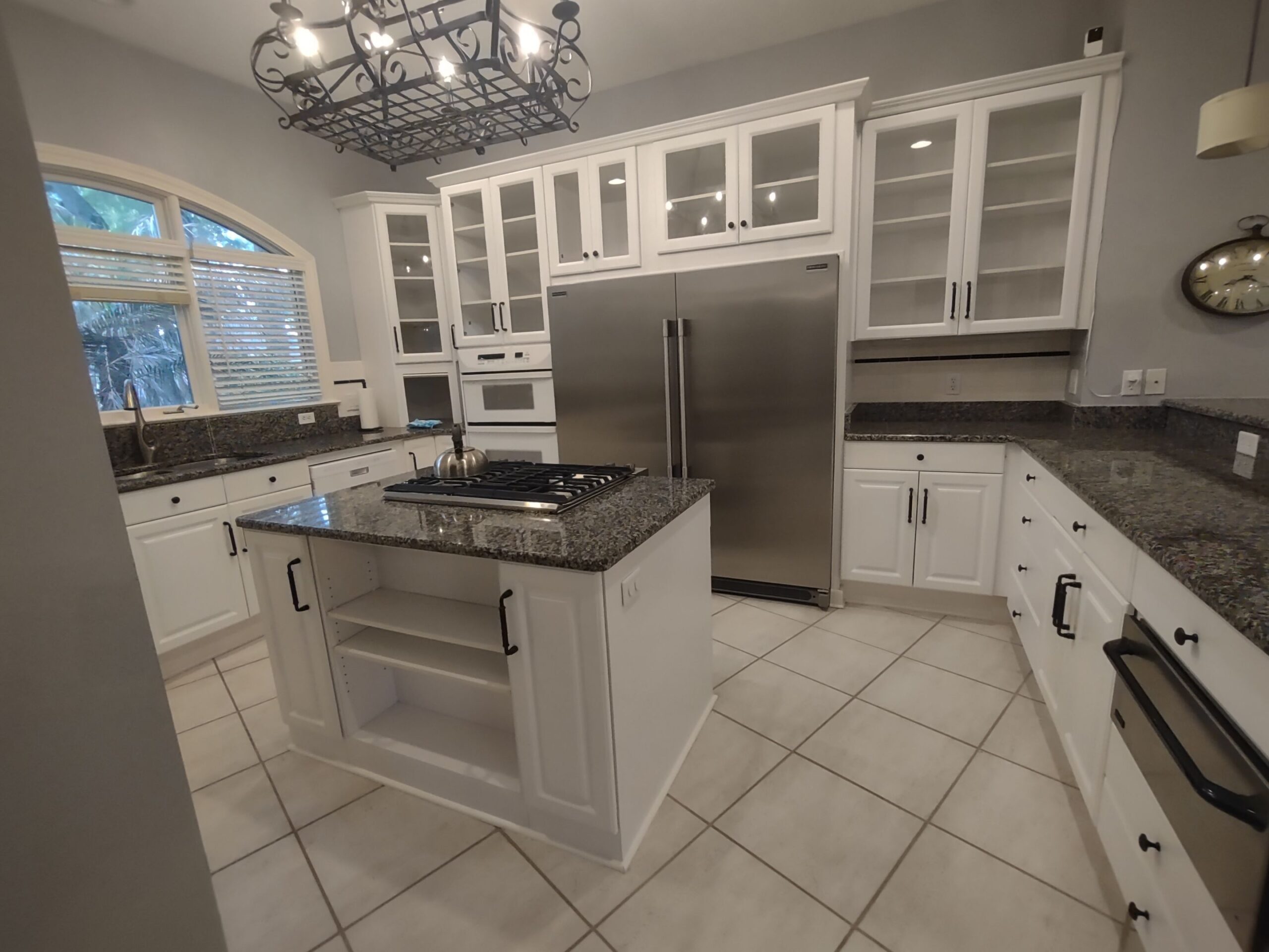5-May 11 2026 12_17pm-QkMU custom cabinets Jacksonville kitchen with white shaker cabinets, stainless range hood, and marble-look backsplash